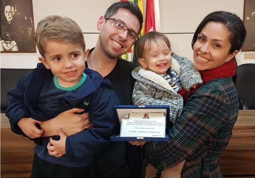 Paulo Sergio com sua família segurando uma placa de homenagem