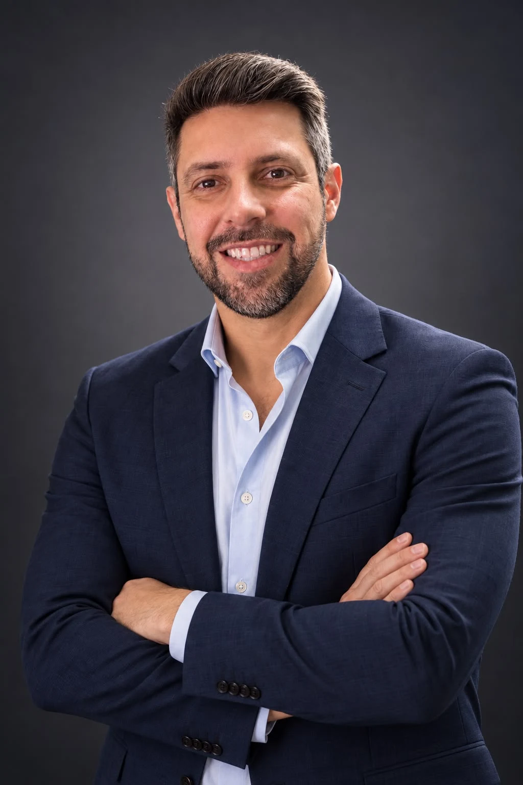 Retrato profissional de Paulo Sergio sorrindo, de braços cruzados